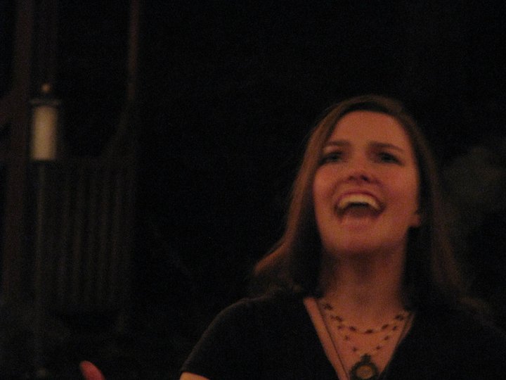 Ren Zatopek sings into the darkness, her head tipped back, her eyes intense. A blurry, mid-ritual photo with palpable energy.